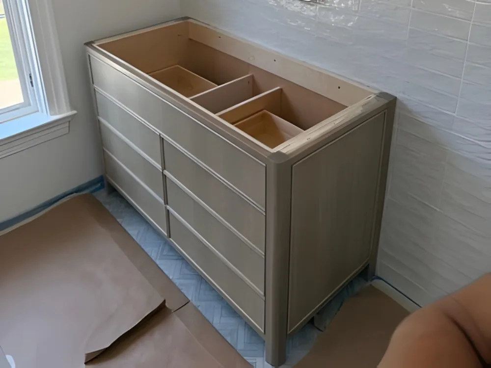 Custom bathroom vanity installation showing finished cabinet structure